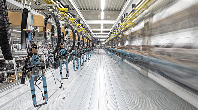 Sinisiä Cube-polkupyöriä tehdaslinjastolla.