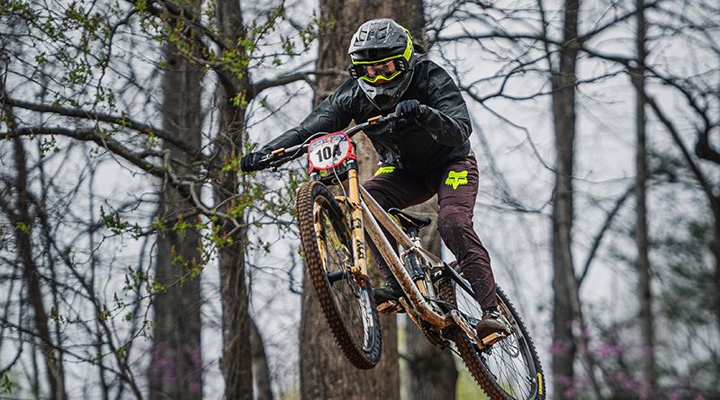 Maastopyöräilijä maastopyörän kanssa ilmassa.