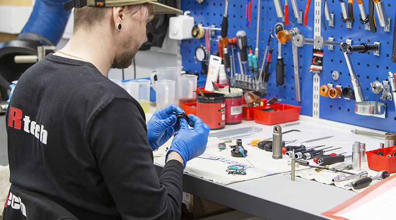 Fox iskunvaimentimien huoltaja tekemässä huoltoa päällään Rtech-paita.