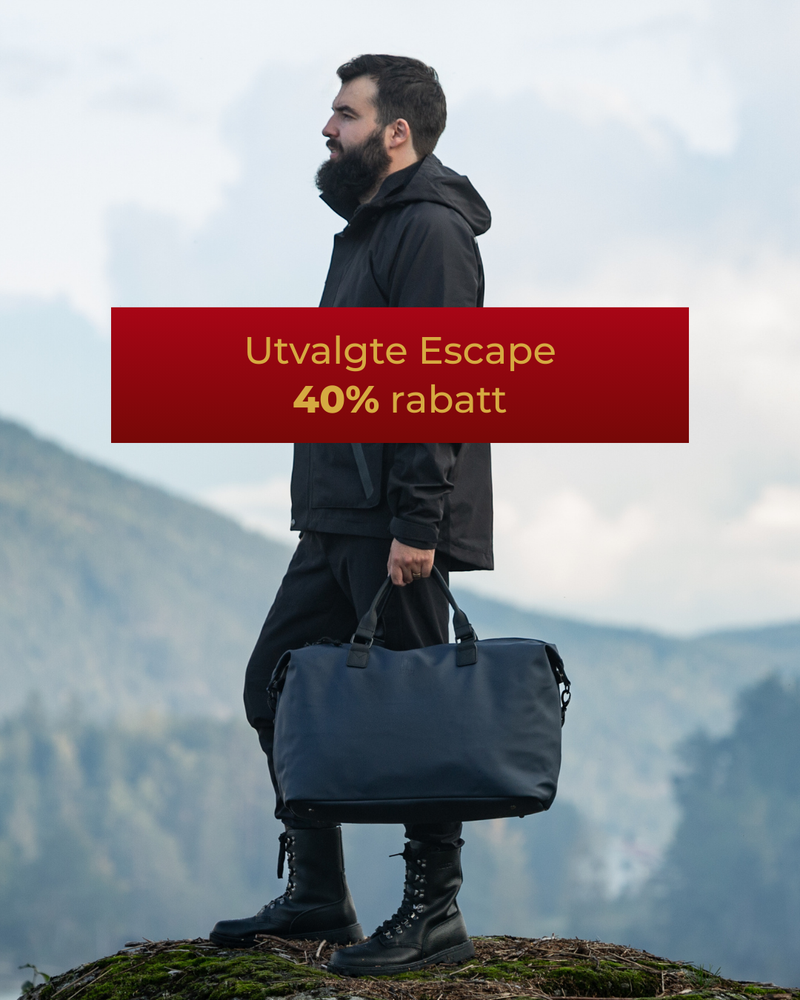 mørkeblå vanntett weekendbag. mann står på et fjell og holder veska. 25% rabatt