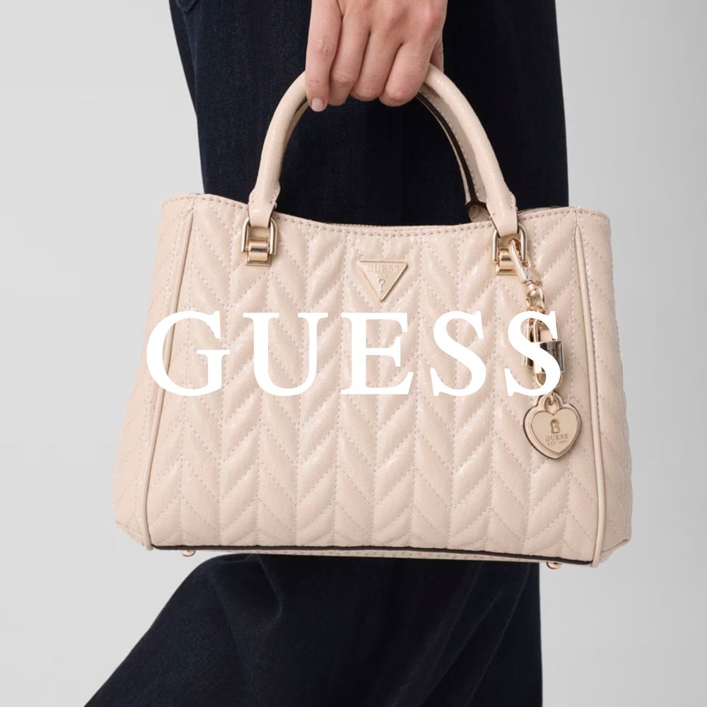 Guess håndveske lysebeige hold av dame i svarte klær
