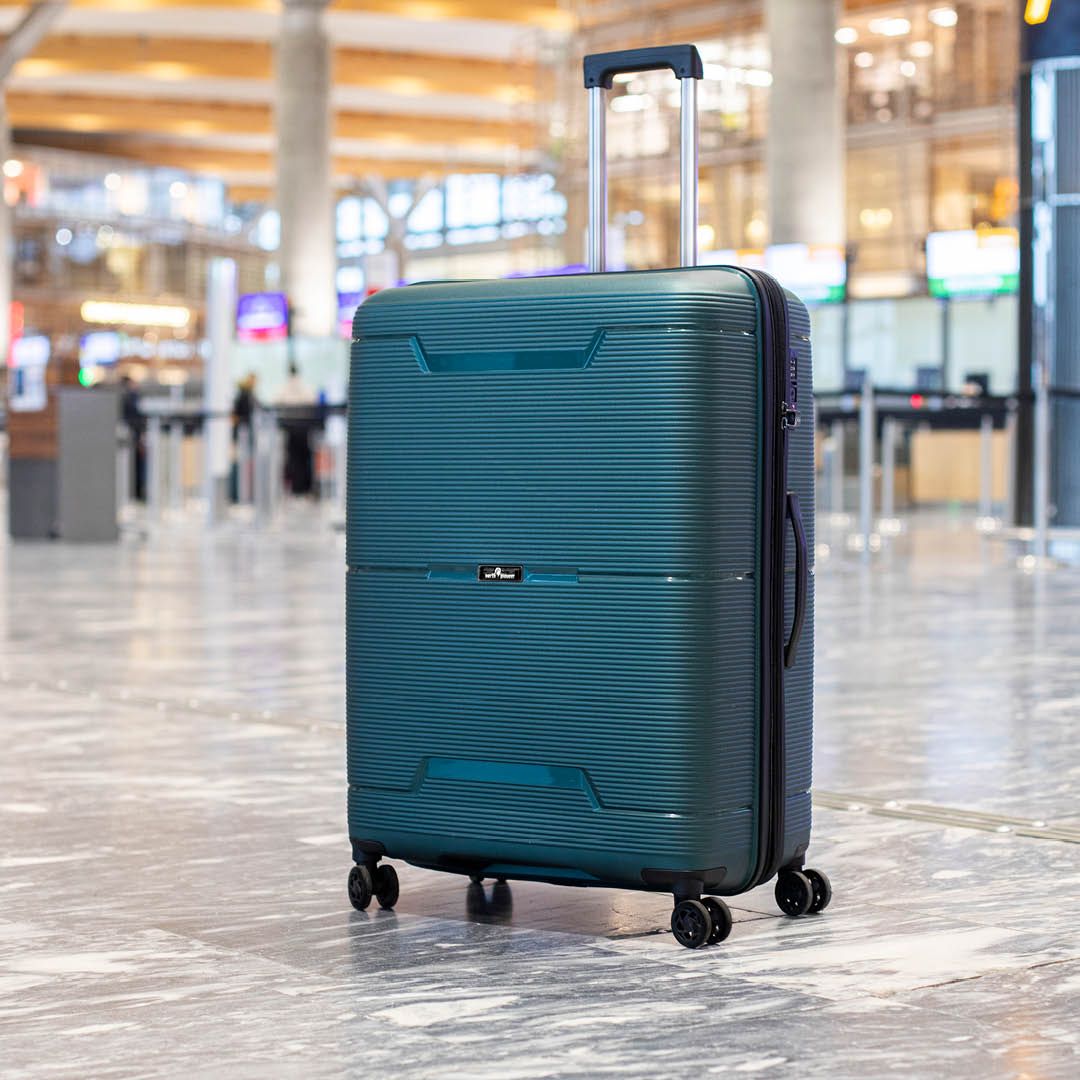 Stor koffert med fire hjul i flyplassterminal