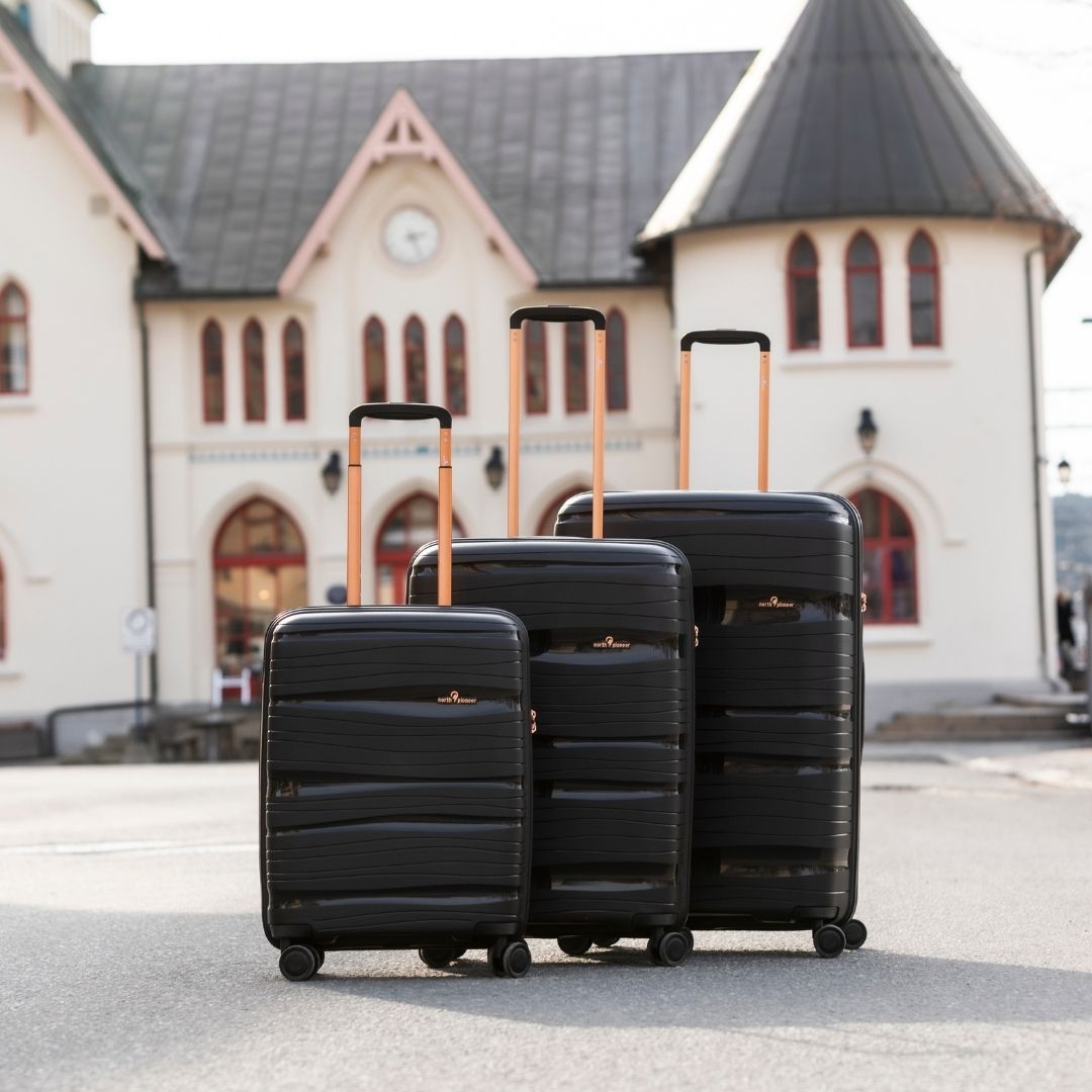 Sorte hardcase trillekofferter i tre størrelser med roségull detaljer ved togstasjon. fra north pioneer
