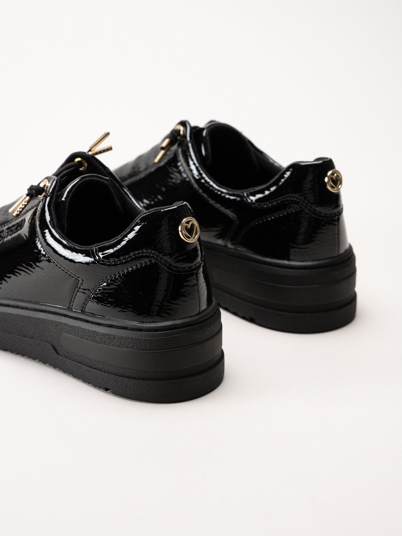 Marco Tozzi - Svarta sneakers i syntetlack med gulddetaljer