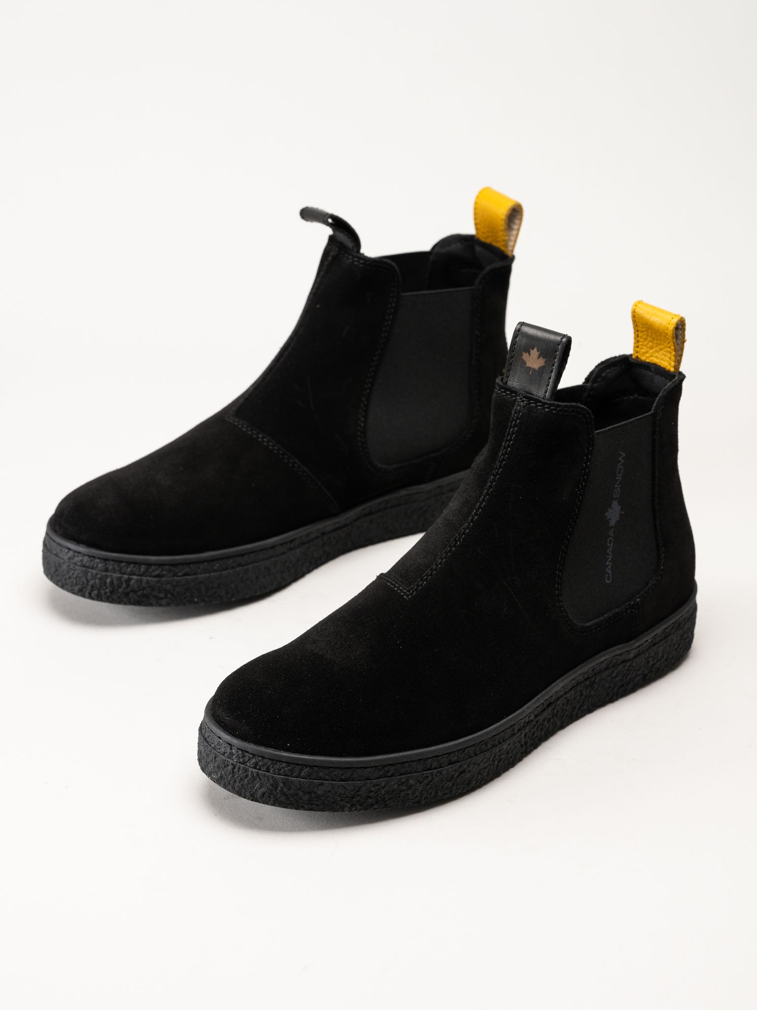 Canada Snow Mount Verm. Svarta Chelsea-boots i mocka med tjocka sulor och gula dragöglor