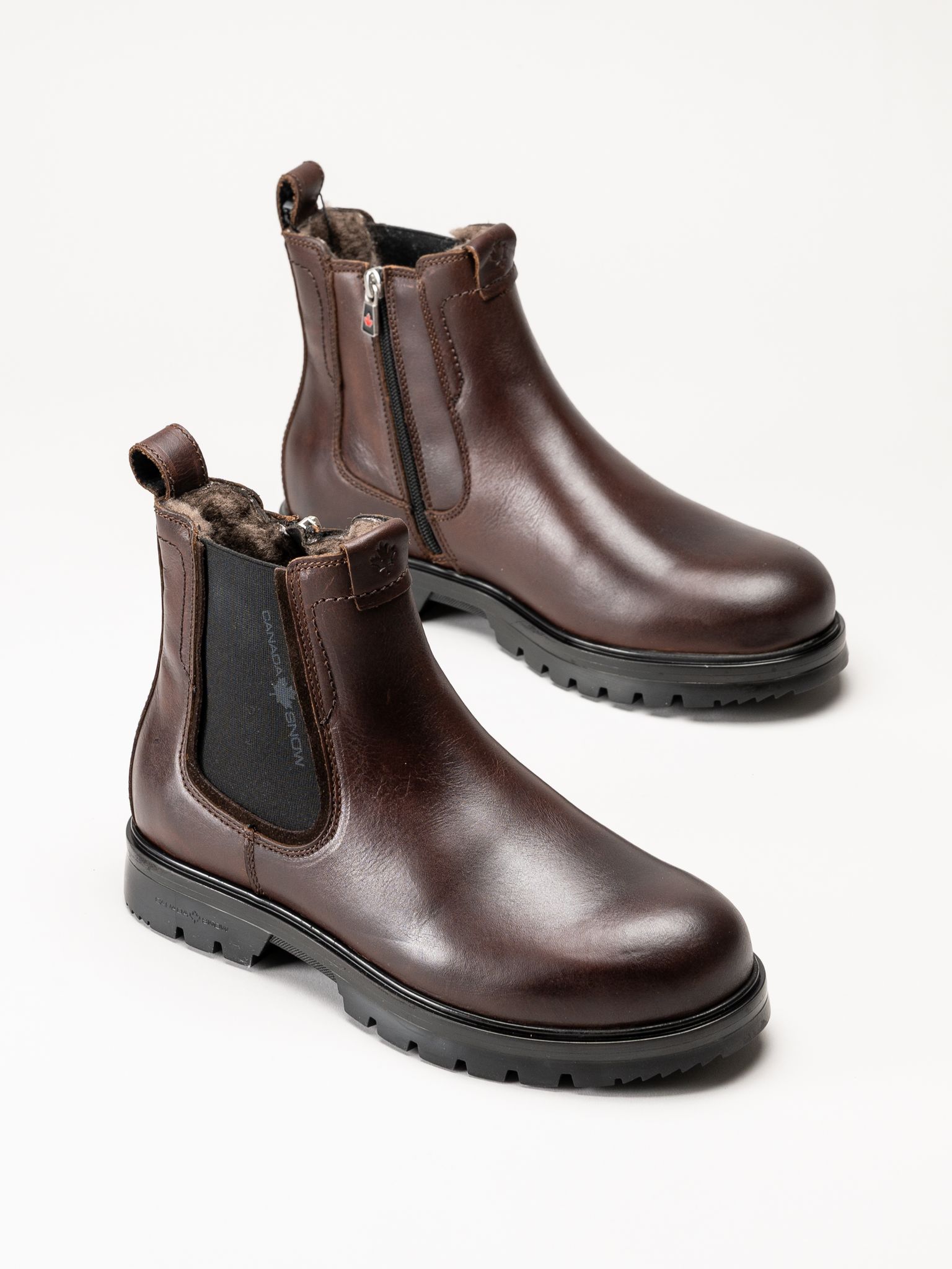 Mörkbruna ankelboots i läder med dragkedjor och kraftiga svarta sulor