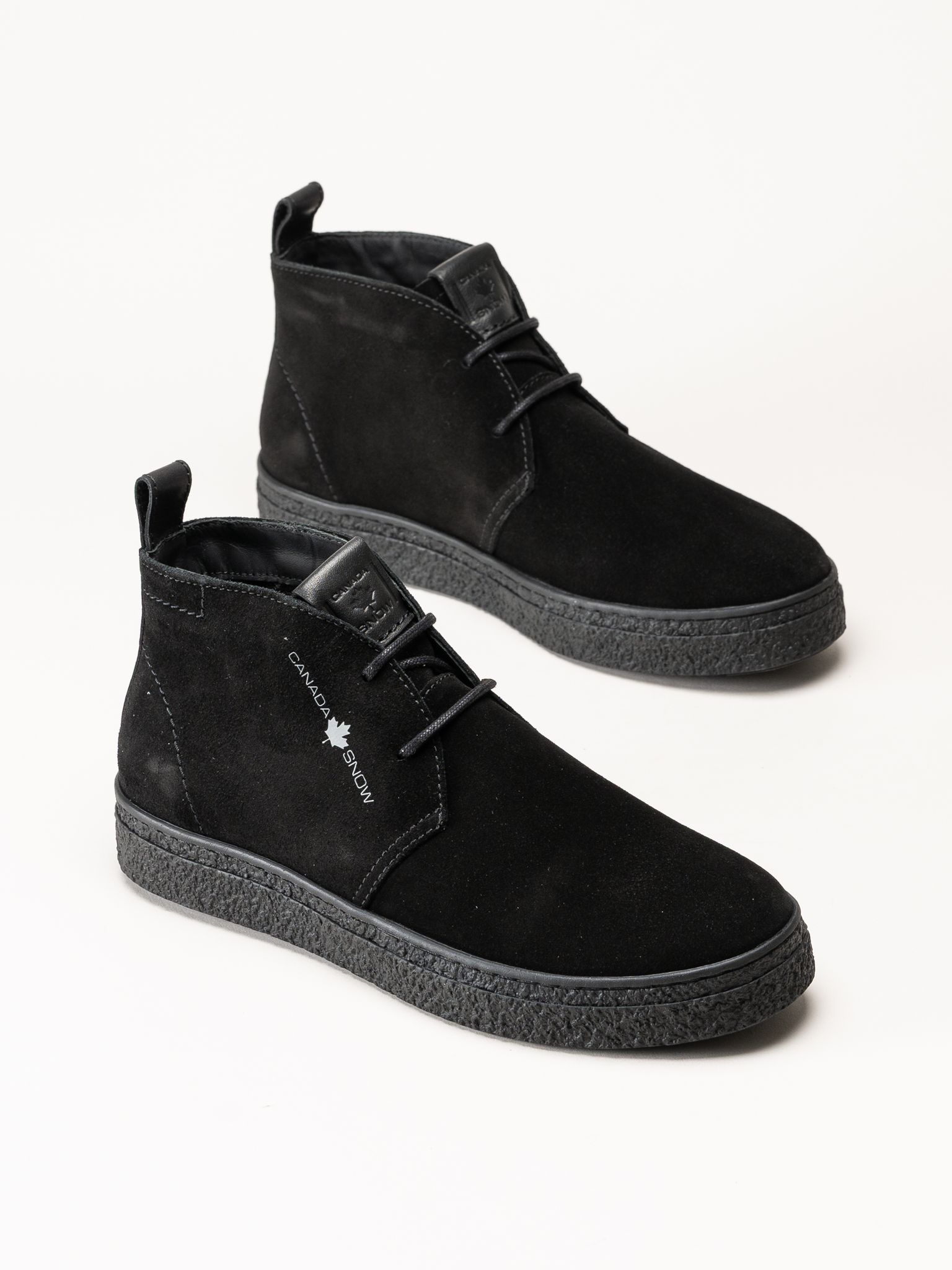 Svarta ankelboots i mocka med snörning och tjocka, mönstrade sulor