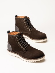 Par mörkbruna ankelboots i mocka med snörning och vita grovmönstrade sulor.