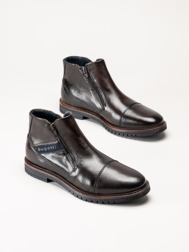 Mörkbruna ankelboots i läder med dragkedja, tåhättor och kraftiga sulor.