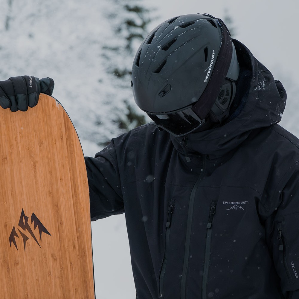 En kille i skidkläder med en snowboard