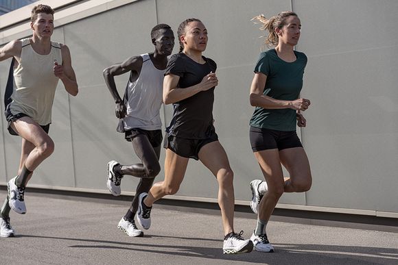 Fyra personer som löper med löpningskläder som är till för löpning