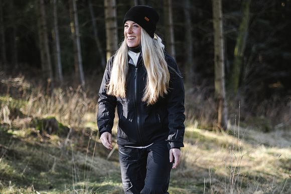 En tjej som är ute och går i naturen i en mörkblå hoodie från Swedemount