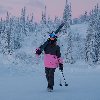 En kvinna som håller i skidor