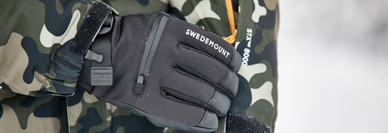 Ett par svarta och varma Swedemount handskar som har vita detaljer på sig