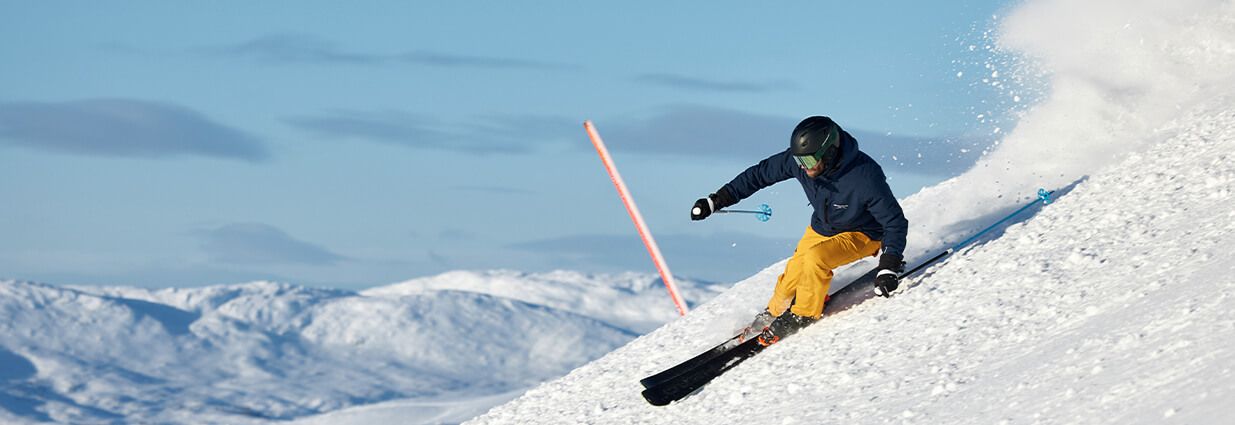 En kille som åker alpint på vintern i en skidbacke med skidkläder ifrån Swedemount och utrustning ifrån Fischer