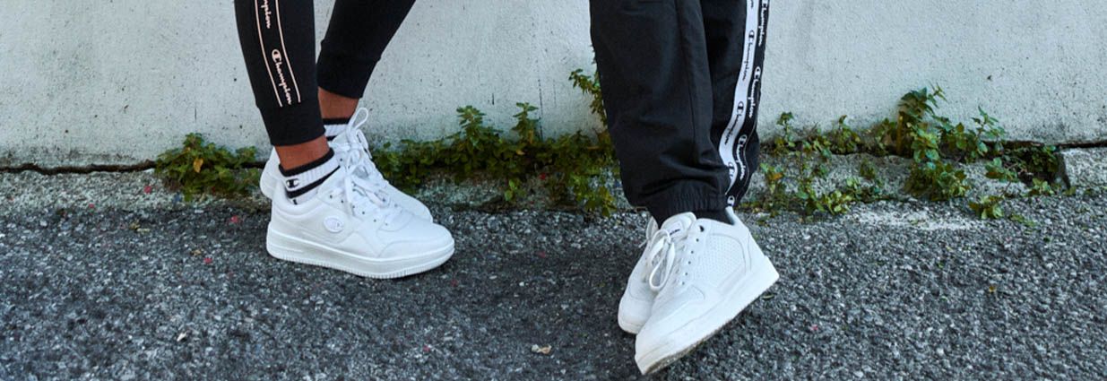 Två par trendiga vita Champions sneakers som är vita 
