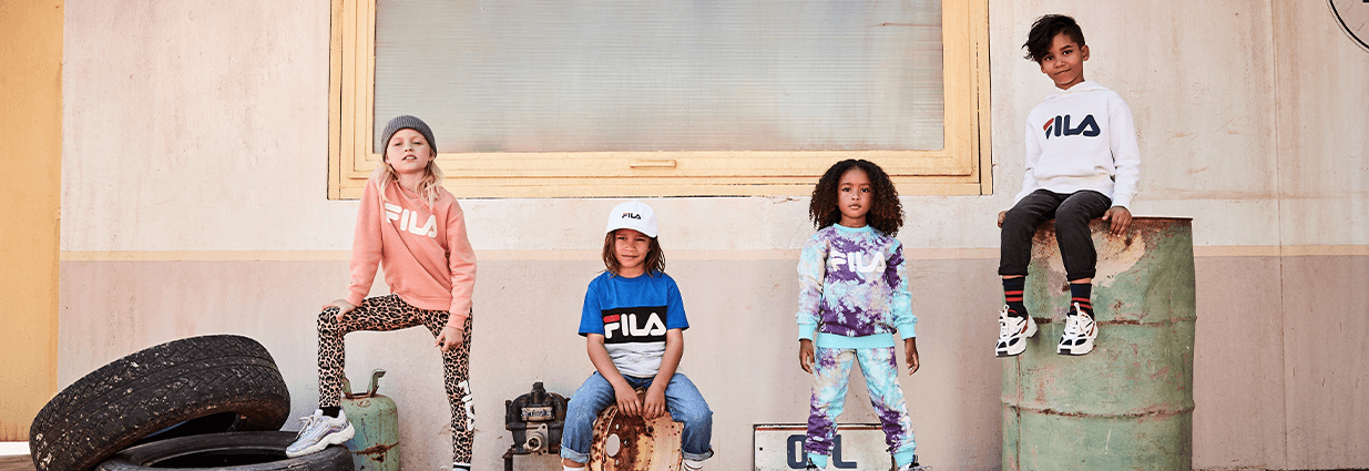 Fire barn/juniorer iført Fila skjorter og bukser som er i forskjellige farger