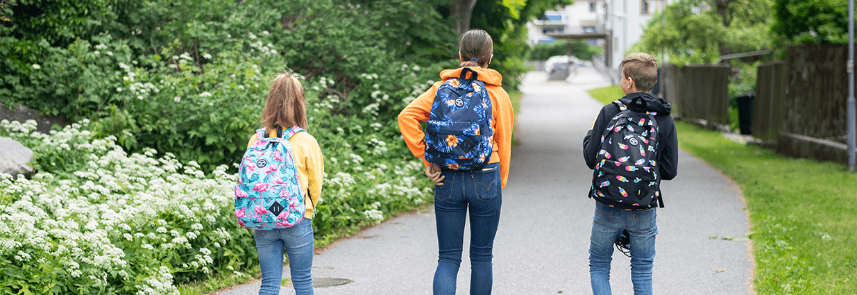 Tre barn/ juniorer som går med accessoarer i form av ryggsäckar i färgerna ljusblått, blått och svart ifrån Blount & pool