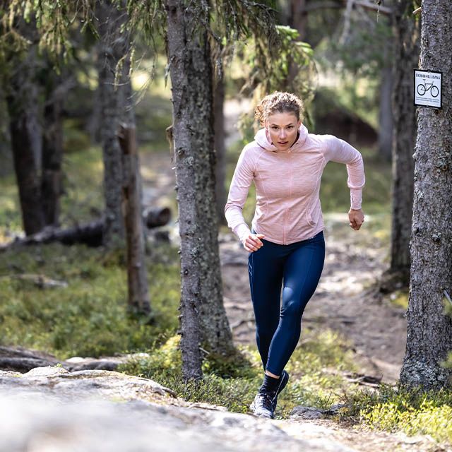 en tjej som springer i skogen
