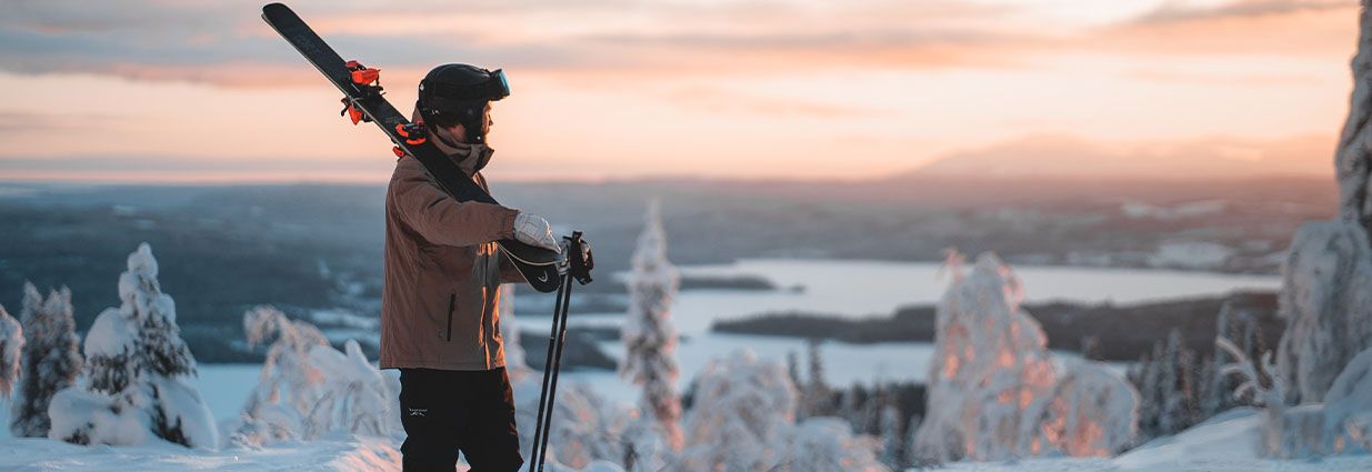 En fyr står med en brun swedemount skijakke med et par svarte varme swedemount skibukser