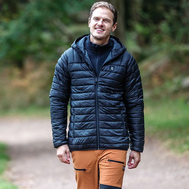En kille som går på berget med en orangea short från Swedemount