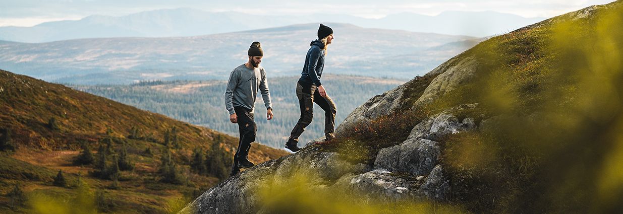 Två personer vandrar i bergen med vandringskläder från Swedemount