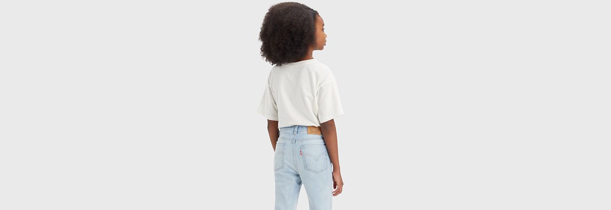 en jente i hvit t-shirt og blå jeans
