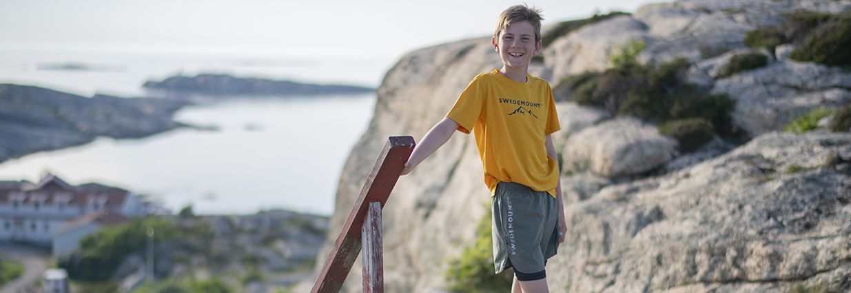 En kille som står i träningsshorts och t-shirt från Swedemount