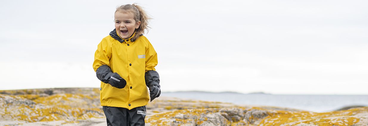 Ett barn som står i ett regnställ från Swedemount