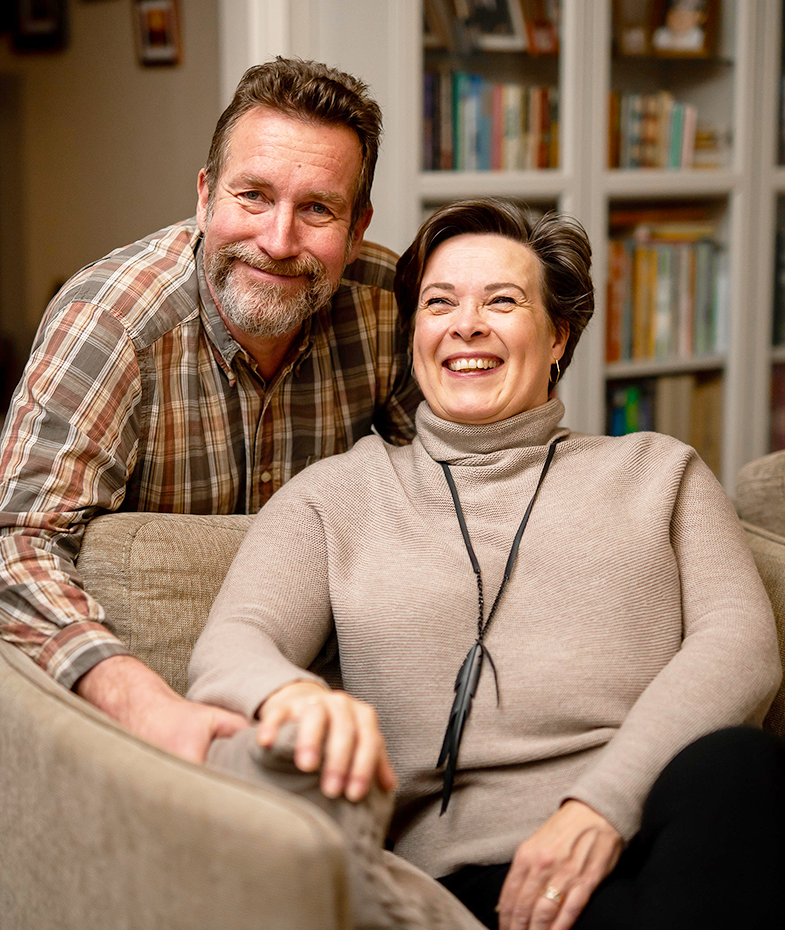 Woman in a grey coat and beanie holding an Immune+ supplement container