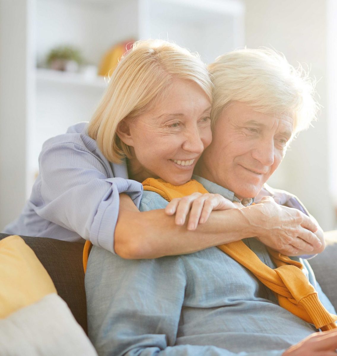 Elderly couple embracing and smiling